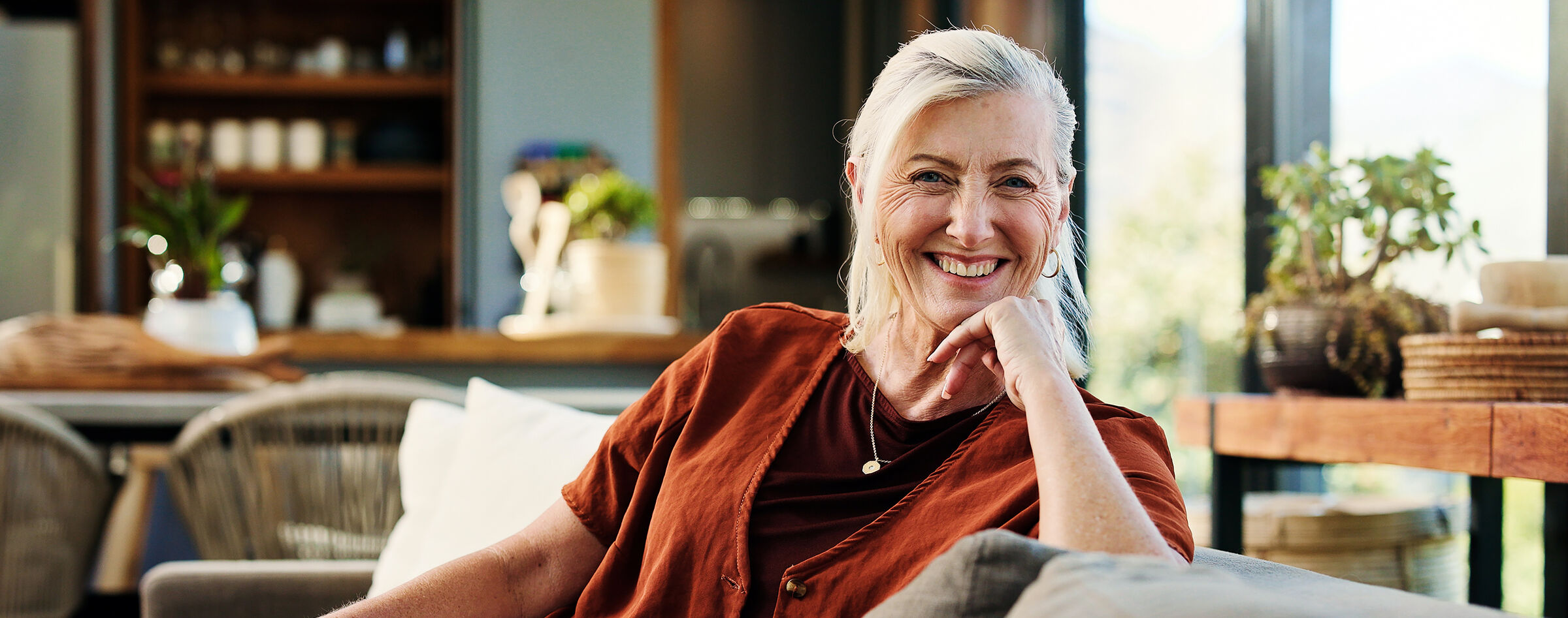 Smiling senior woman relaxing at home in a sunlit living room