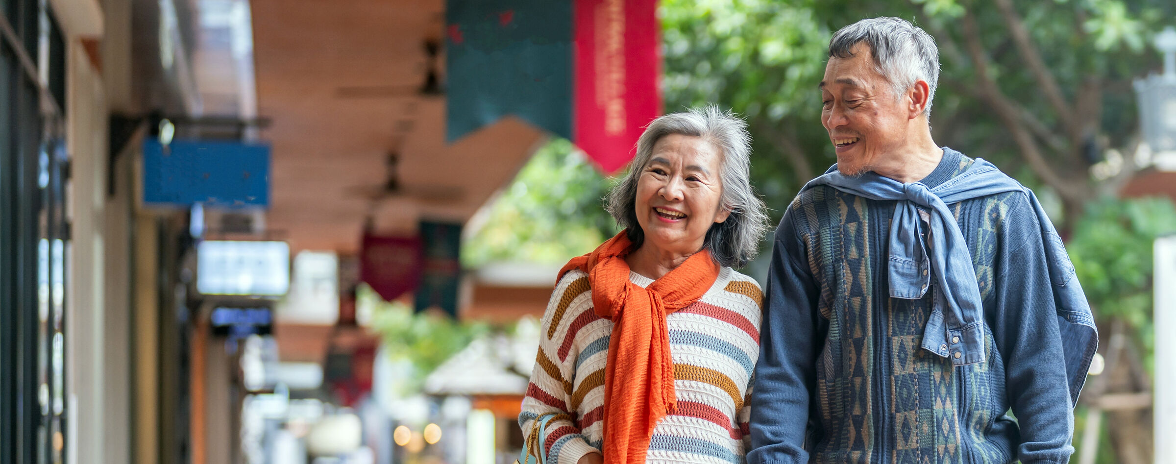 Senior couple strolling past shops on a walkable street